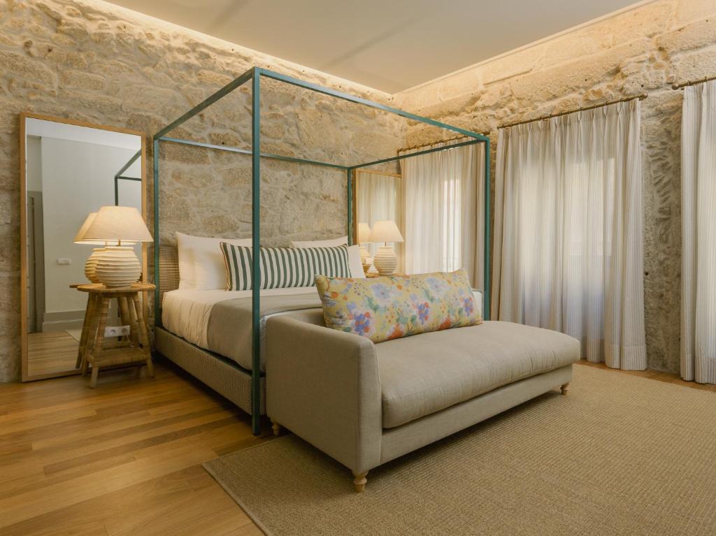 a bedroom with a canopy bed and a couch at Bonjardim 560 in Porto
