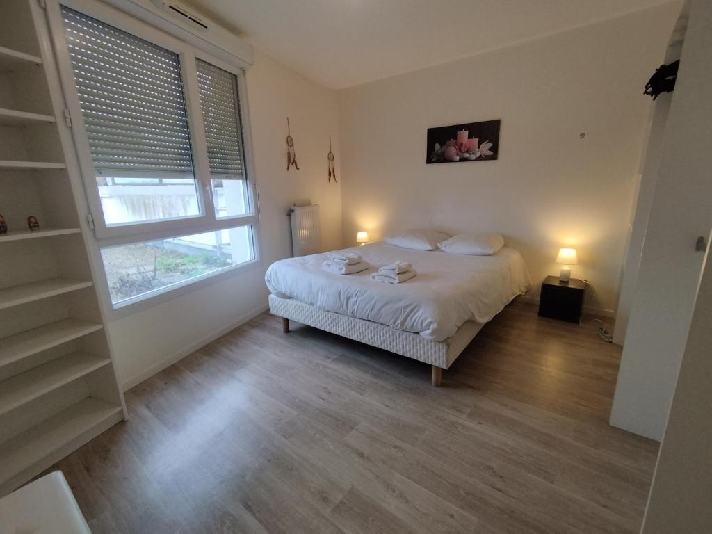 a bedroom with a bed and a large window at SAINT DENIS appartement 2 chambres avec parking in Saint-Denis