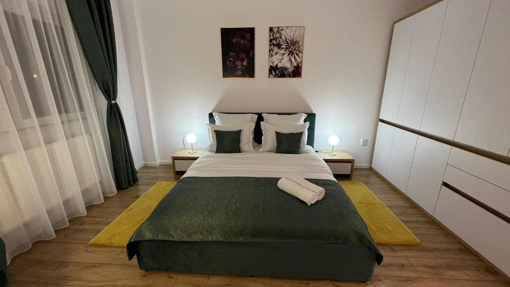 a bedroom with a large bed and two lamps at Aparthotel Junior4 Cluj in Cluj-Napoca