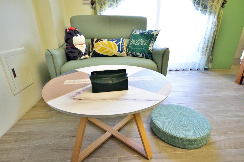 a coffee table in a living room with a chair at Piau Po 21 Inn in Taitung City