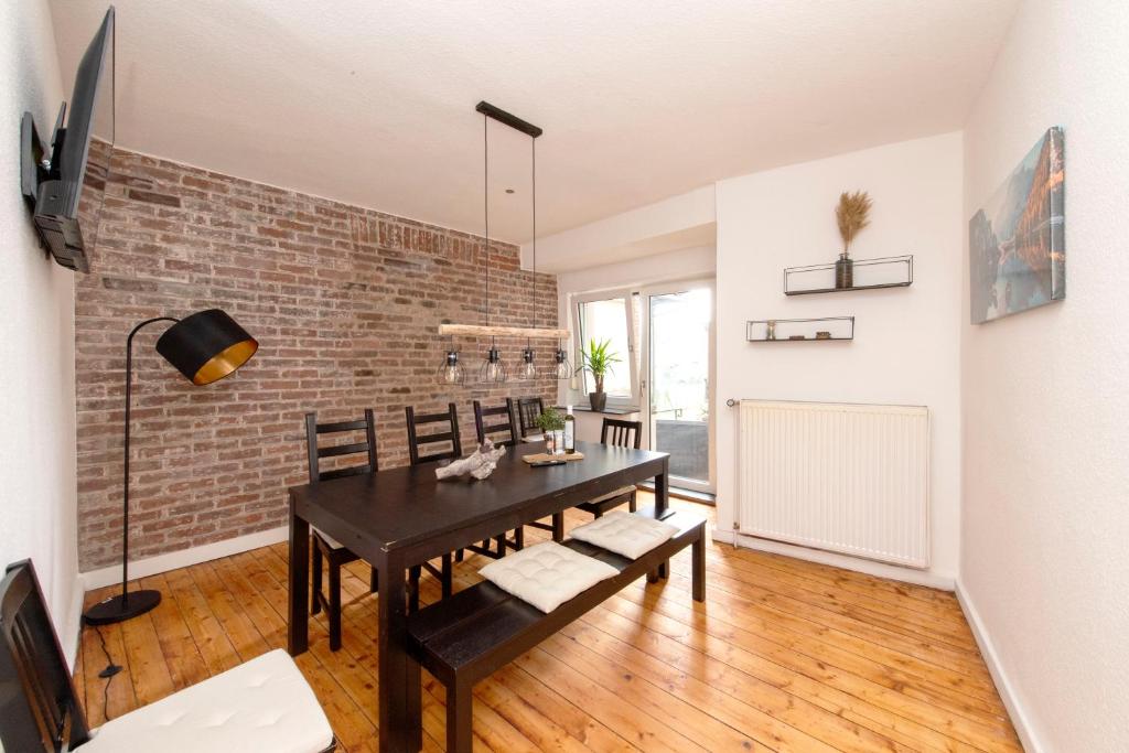 une salle à manger avec une table et un mur en briques dans l'établissement Cozy Apartment ° 7 beds ° 3 bed rooms, à Clèves