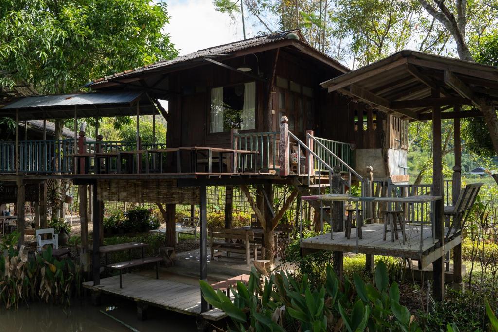 una casa en el árbol con terraza y sillas en Art House at Chiangdao - Moon House, en Chiang Dao