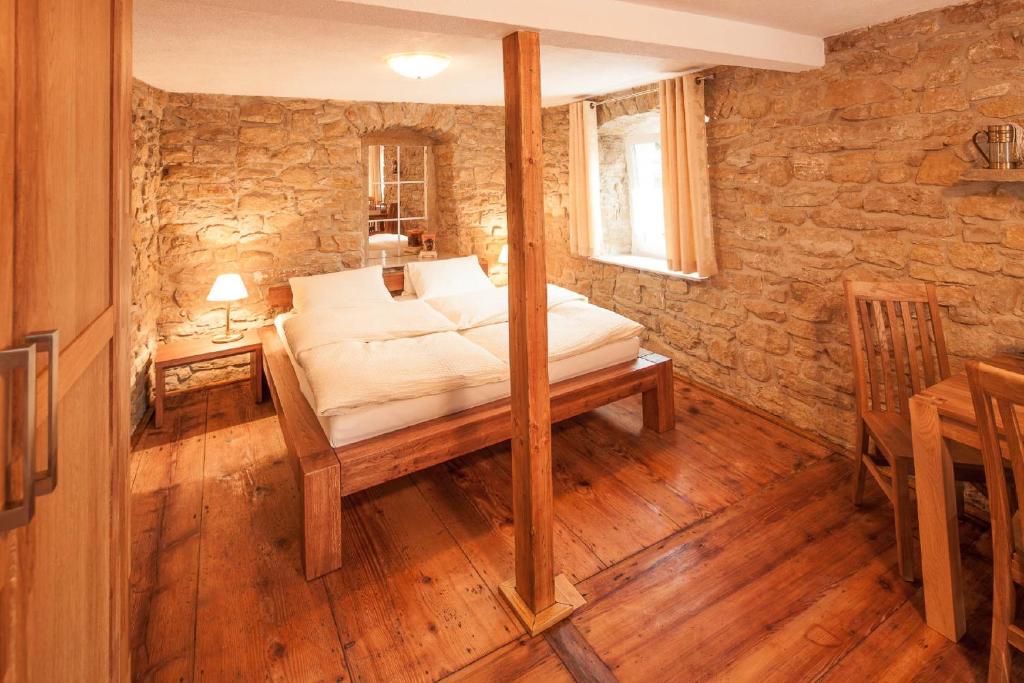 a bedroom with a bed in a stone wall at Ferienwohnung Pfaffenweiler in Pfaffenweiler