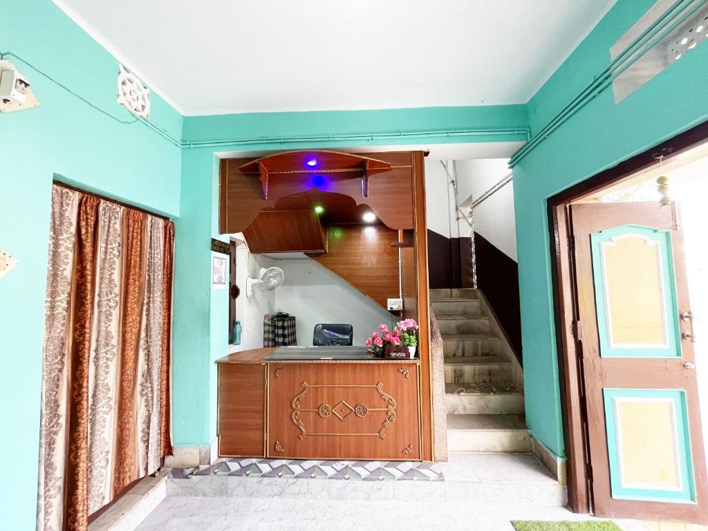a room with a kitchen with blue walls and a staircase at Radha Krishna Holiday Home in Puri