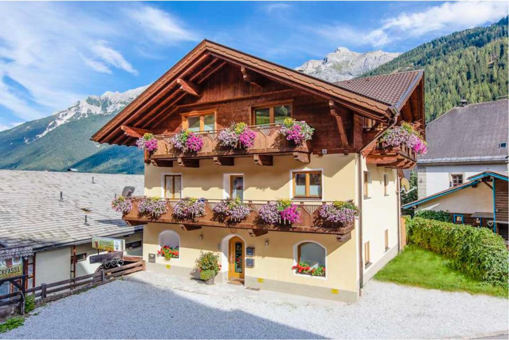 a house with flowers on the balconies of it at Falwesuna Apartments in Neustift im Stubaital