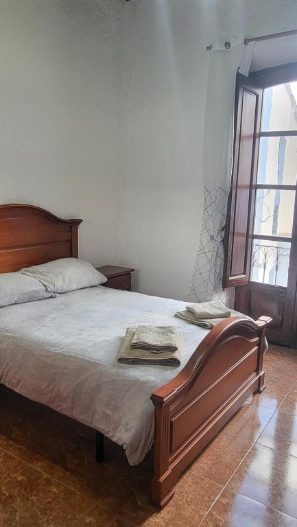 a bedroom with a bed with a wooden headboard and a window at Villa Alegria in Gérgal