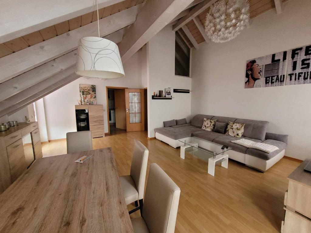 uma sala de estar com um sofá e uma mesa em Ferienwohnung Hegau em Hilzingen