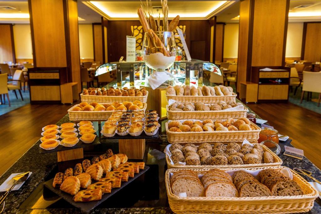 A central buffet display is piled with pastries, bread, and small baked goods.
