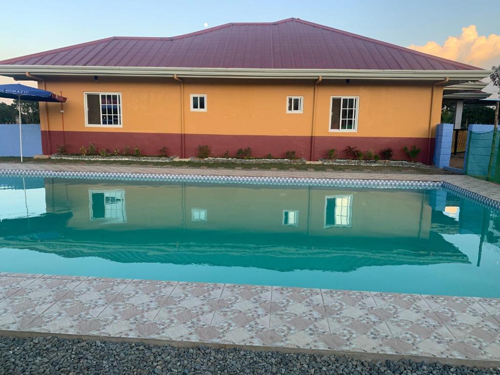 a house with a swimming pool in front of it at Scarlett Resorts-Pangasinan, Philippines in Bugallon