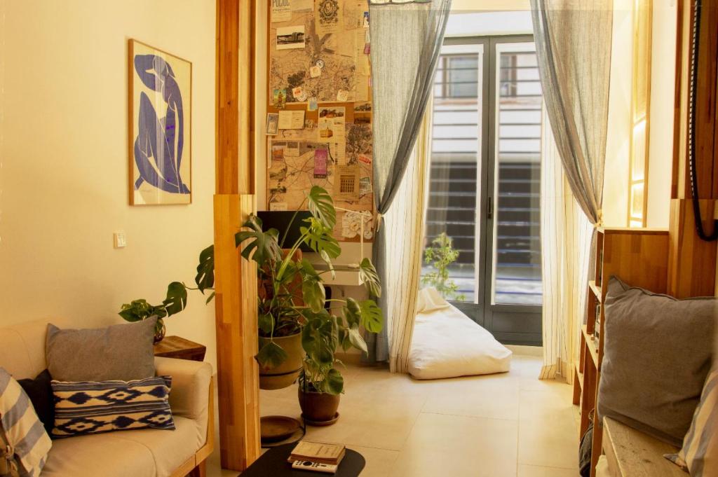 a living room with a couch and potted plants at 4 Bears Studios in Madrid