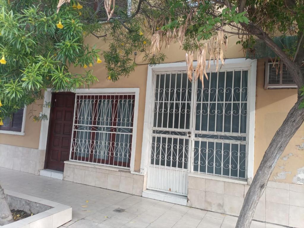 un edificio con dos ventanas con barrotes. en CONFORTABLE DUPLEX CON GARAGE en Santiago del Estero