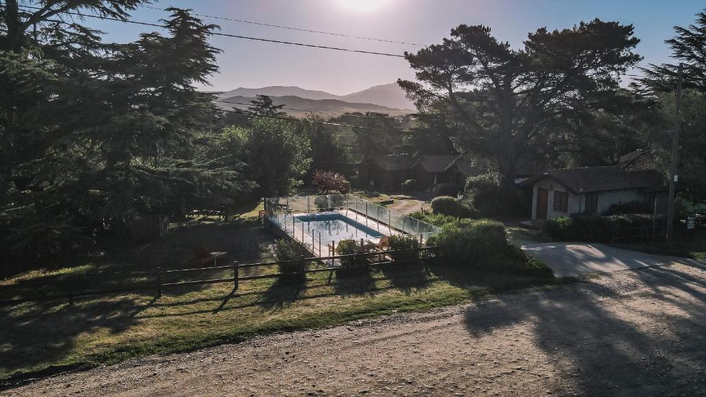 a house with a swimming pool in a yard at Cabañas del Golf in Sierra de la Ventana