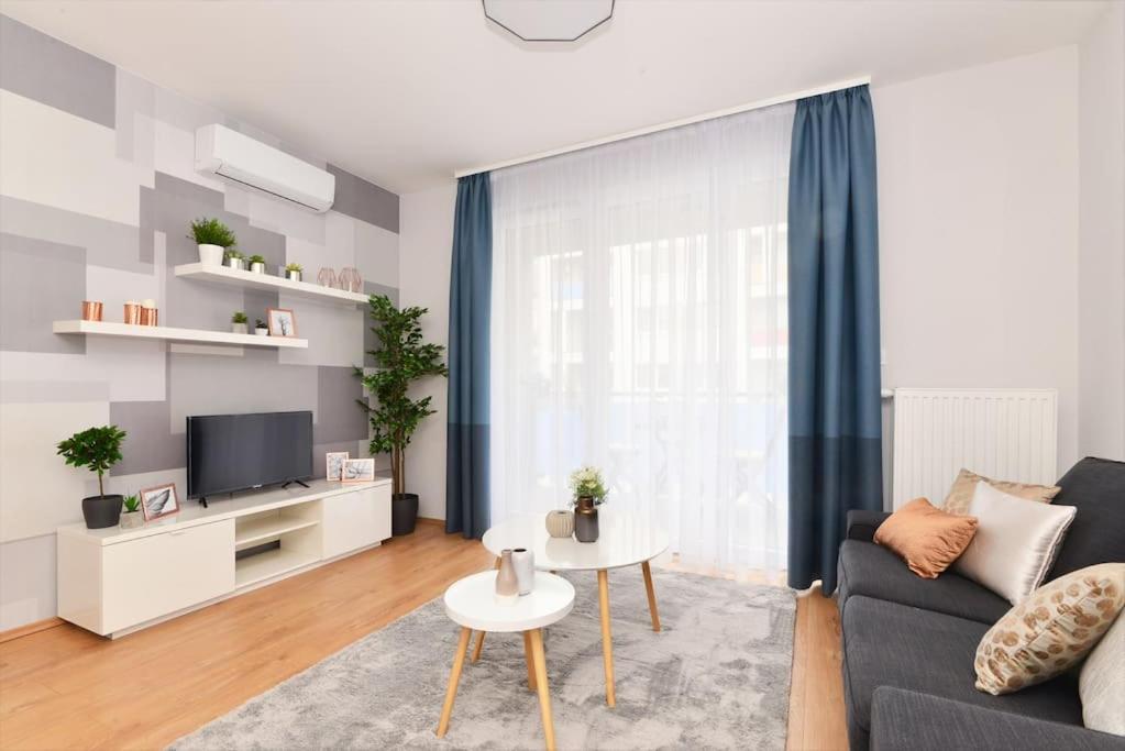 sala de estar con sofá y TV en Laurel Bay Apartment, en Budapest