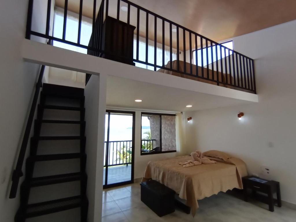 a bedroom with a bed and a staircase at Tapirus Playa in Drake