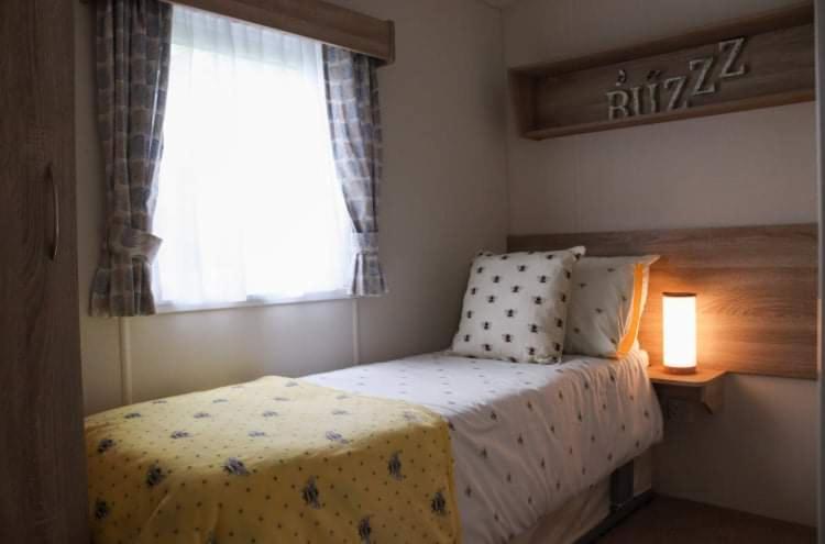 Habitación pequeña con cama y ventana en Bimble Lodge en Langport
