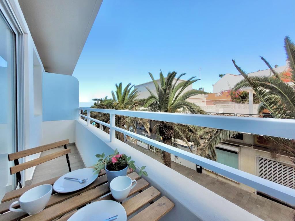 balkon ze stołem, krzesłami i palmami w obiekcie La Hoya 29 Apartments w Puerto de la Cruz