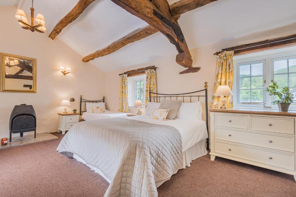 1 dormitorio con 2 camas y ventana en farmhouse cottage, en Keswick