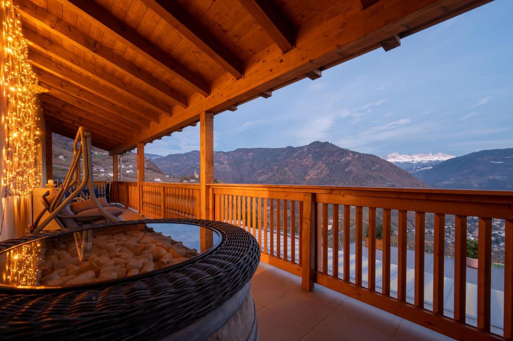 um deque com uma banheira de hidromassagem e vista para as montanhas em Appartement Schusterhof em Gries