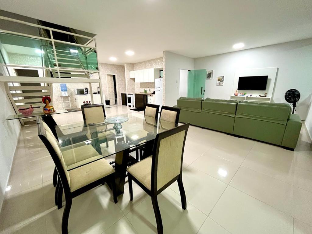 a dining room with a glass table and chairs at Casa em Porto de Galinhas by AFT in Porto De Galinhas