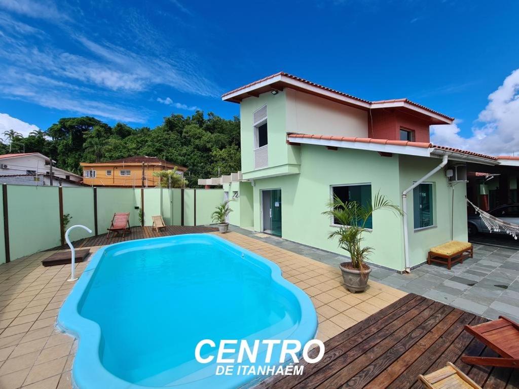 eine Villa mit einem Pool und einem Haus in der Unterkunft Vila Itanhaém in Itanhaém