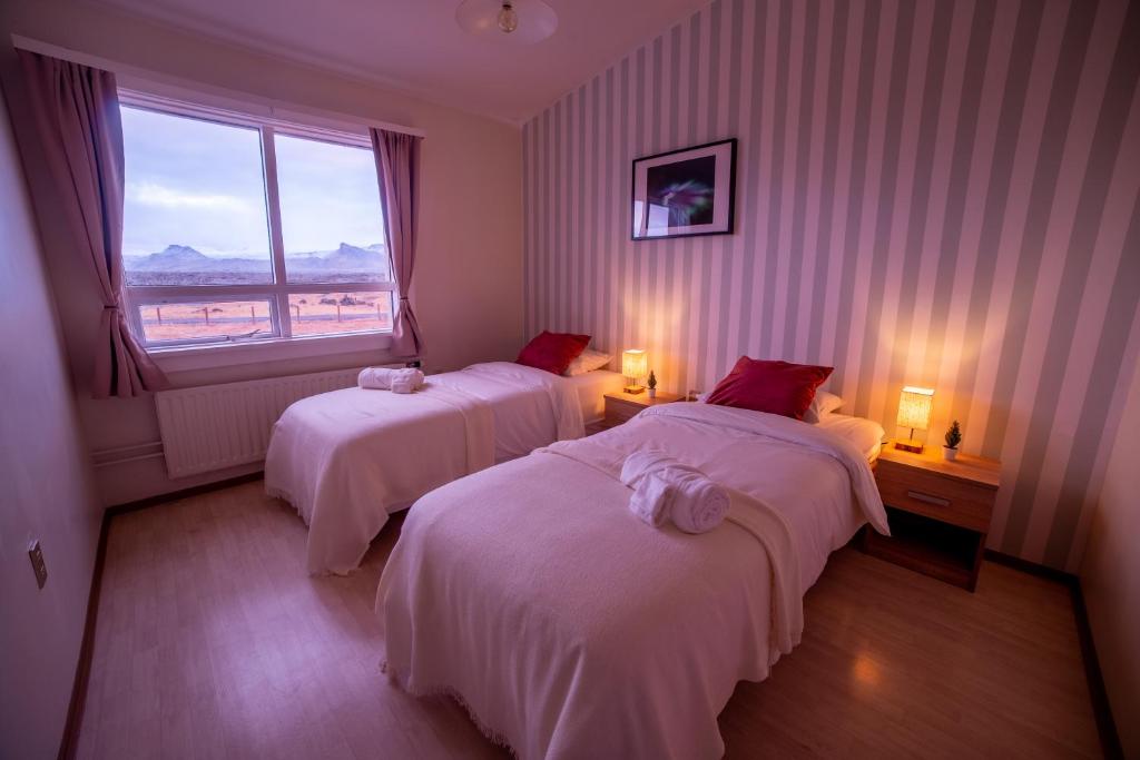um quarto de hotel com duas camas e uma janela em Snæfellsjökull Apartments em Snæfellsbær