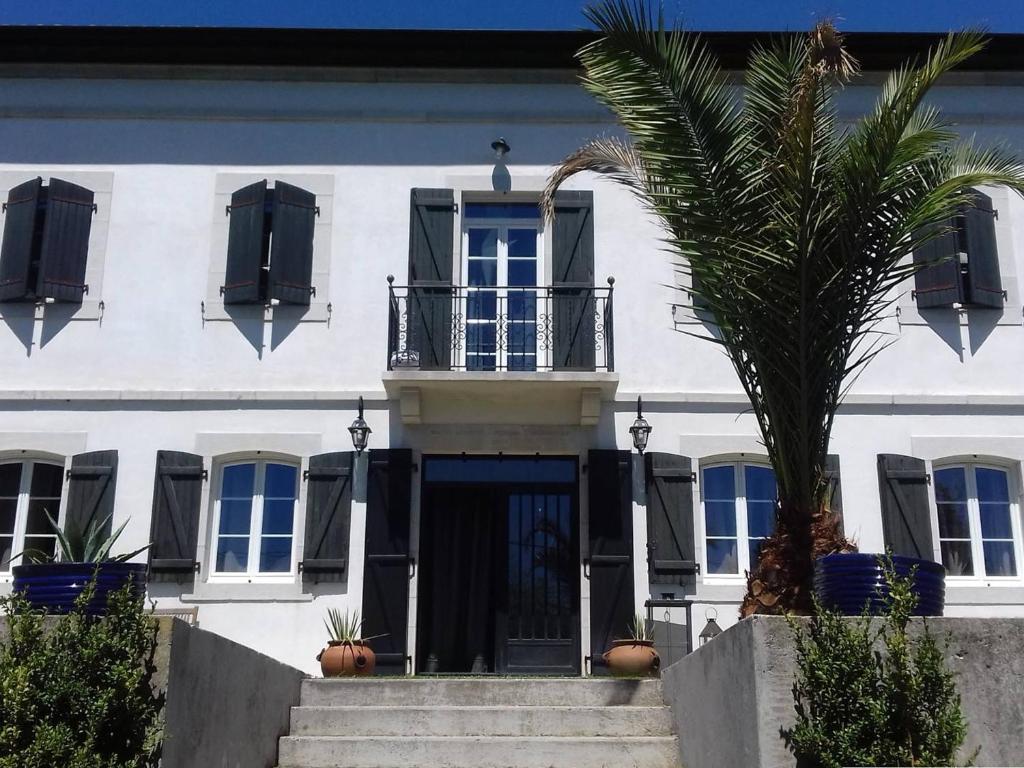 un edificio blanco con una palmera delante en Maison Mendionde, 5 pièces, 8 personnes - FR-1-495-104, en Mendionde