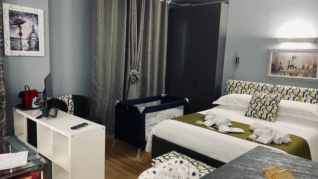 ein Hotelzimmer mit 2 Betten und einem Schreibtisch in der Unterkunft Le Chicche del Porto - Bleu in Genua