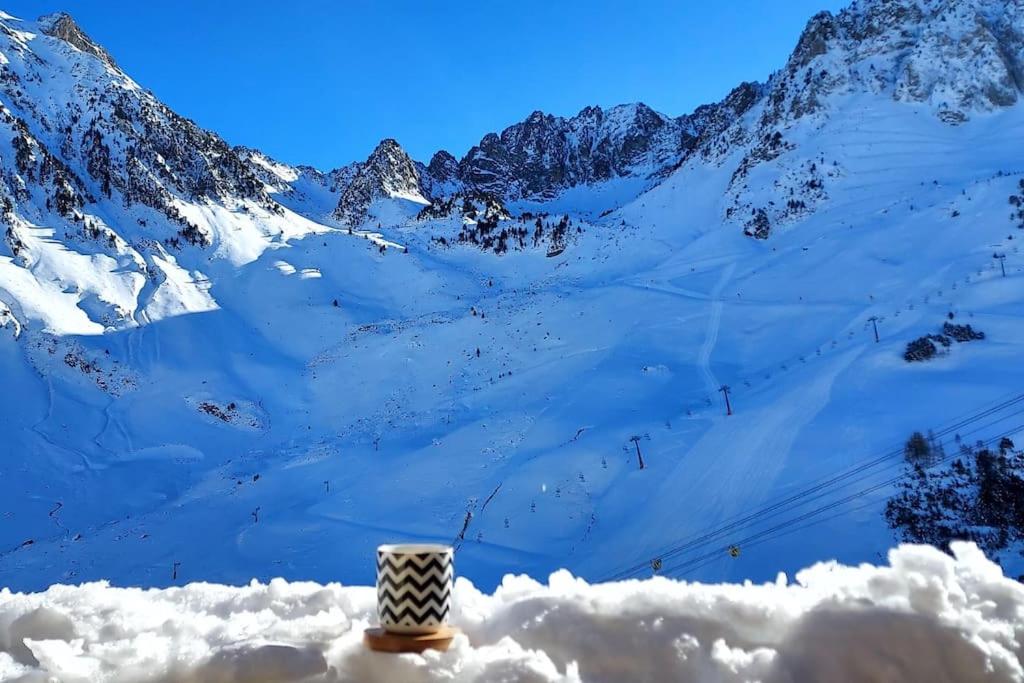 una taza de café en la cima de una montaña nevada en Le perchoir de Juliette en La Mongie