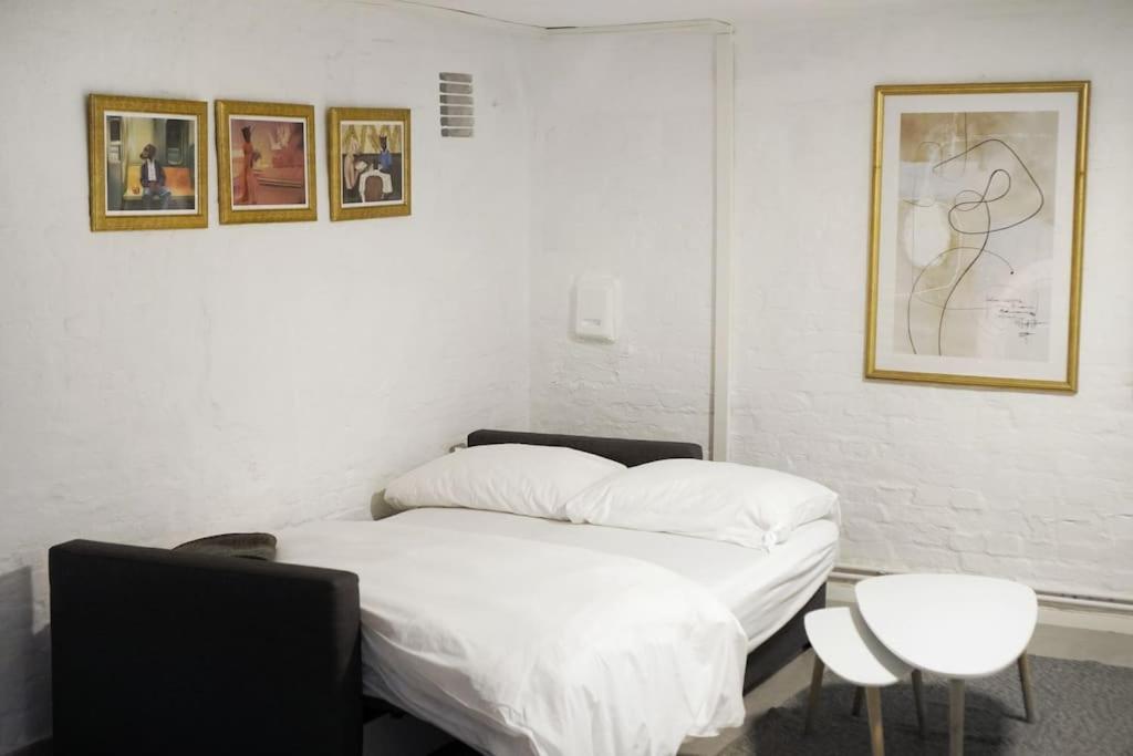 柏林的住宿－Central, cozy & beautiful designed 2-rooms Apt. near river，卧室配有白色的床和墙上的两张照片