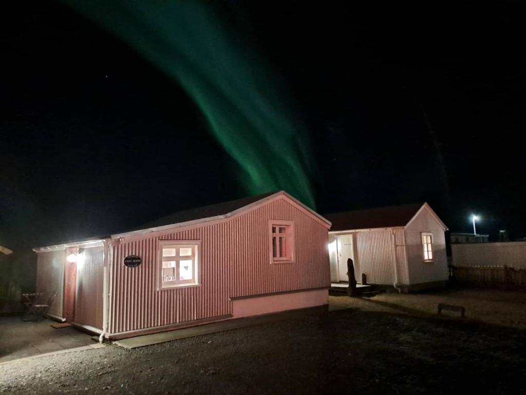 una casa con l'aurora sopra di essa di notte di Sea Side Cottages a Eyrarbakki