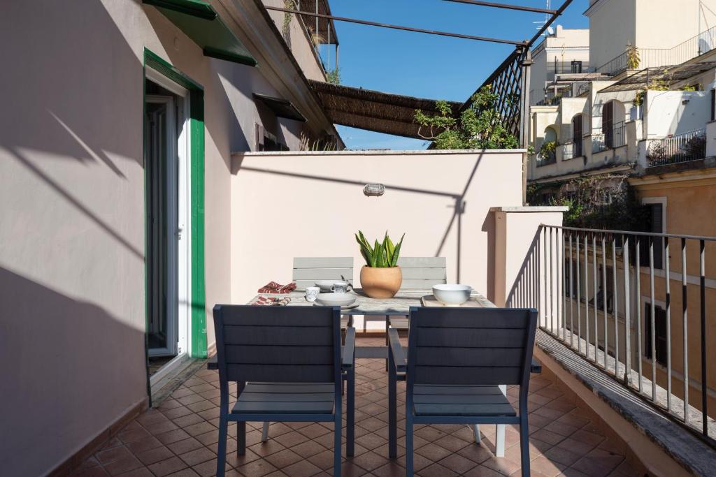um pátio com uma mesa e cadeiras numa varanda em Urbana Rooftop em Roma