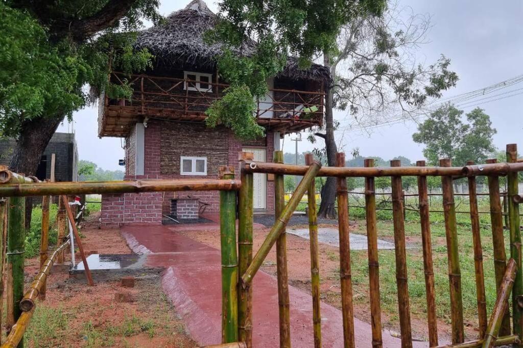 a wooden fence in front of a building at Woodside Haven in Auroville