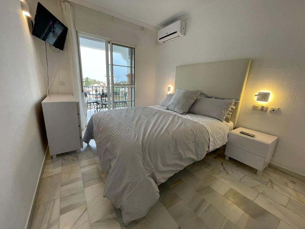 ein Schlafzimmer mit einem Bett und einem TV in der Unterkunft El Mirador de Mijas Piscina y Parking gratis in Málaga