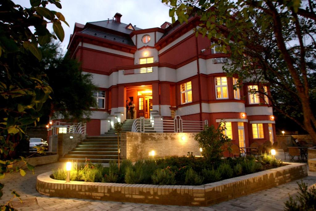 a red building with lights in front of it at Hotel Villa in Prague