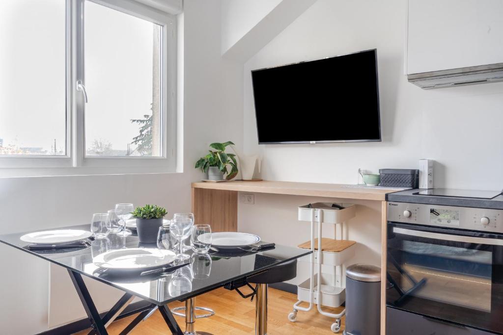 a dining room with a table and a tv at Appartement Chantenay 4 pers in Nantes