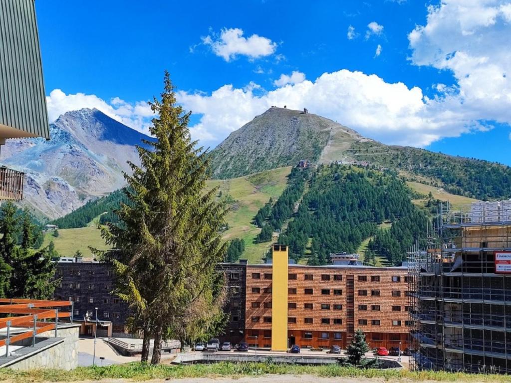 a city with a tree and mountains in the background at La Casa di Giorgia in Sestriere