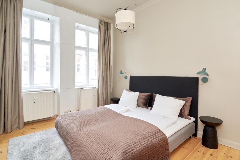 um quarto com uma cama grande e uma janela grande em Scandinavian Style 3BR in Copenhagen City Centre em Copenhague