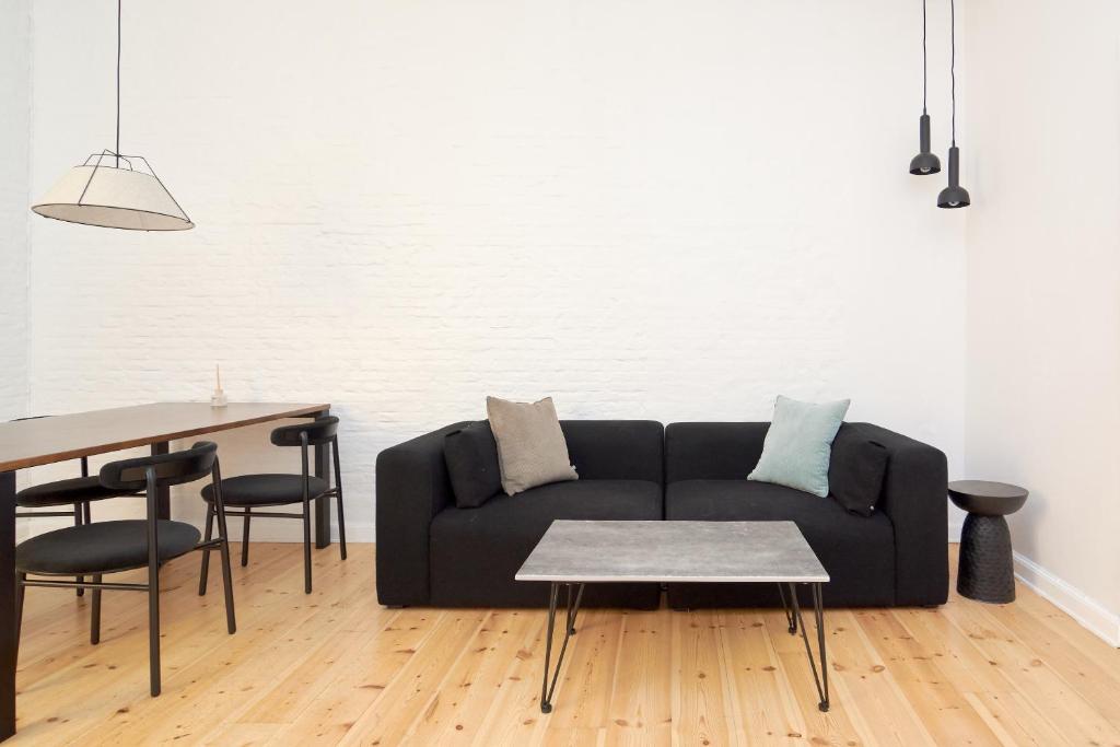 sala de estar con sofá negro y mesa en Scandinavian Style 3BR in Copenhagen City Centre, en Copenhague