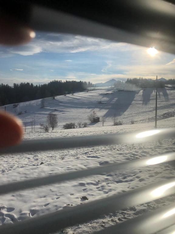 a view of a snow covered field from a train window at Green Hill Apartment - Domek na Wyłączność in Leśnica