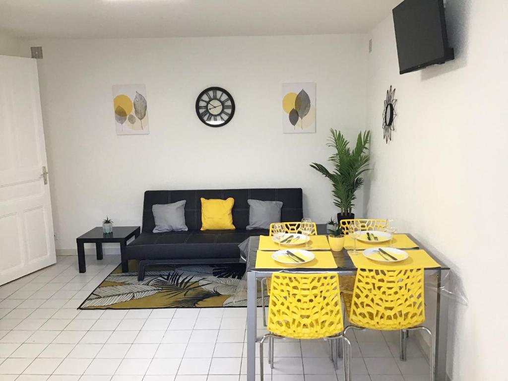 - un salon avec un canapé, des tables et des chaises jaunes dans l'établissement Appartements Sun, parking, centre ville , proche Sanctuaires, à Lourdes
