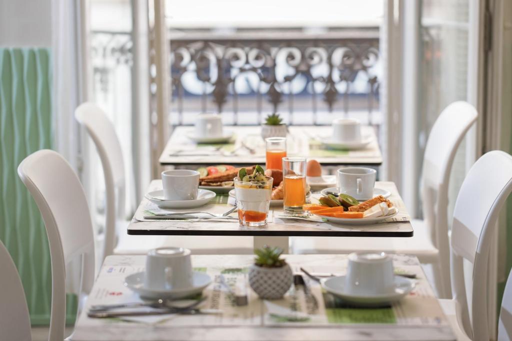 a table with plates of food and drinks on it at Hotel Florence Nice in Nice
