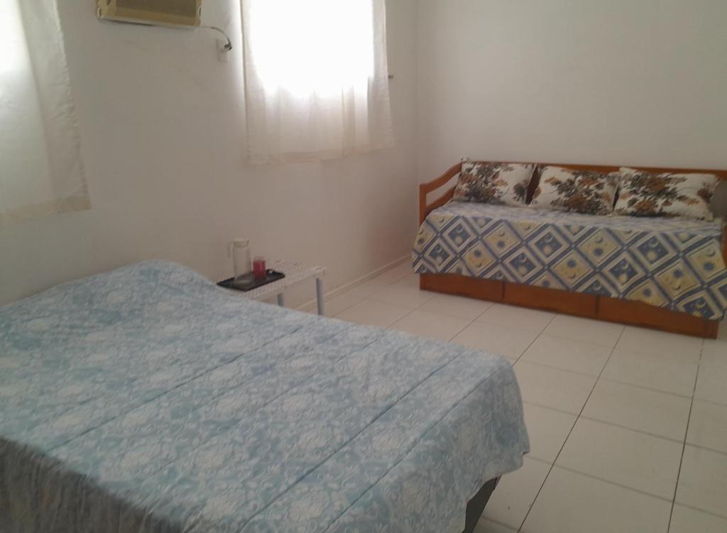 Cette chambre comprend 2 lits et une fenêtre. dans l'établissement Pousada CNU, à Rio de Janeiro