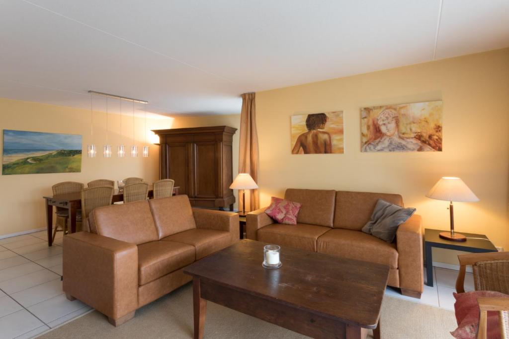 ein Wohnzimmer mit einem Sofa und einem Tisch in der Unterkunft Hello Zeeland - Appartement Loverendale 24 in Domburg