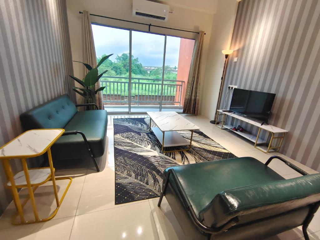 ein Wohnzimmer mit einem Sofa und einem TV in der Unterkunft Pavilionvillie M1T11 by irainbow in Simpang Pulai