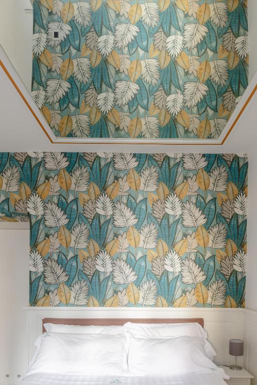 a bedroom with a bed and a floral wallpaper at Relais Roma Centro in Rome