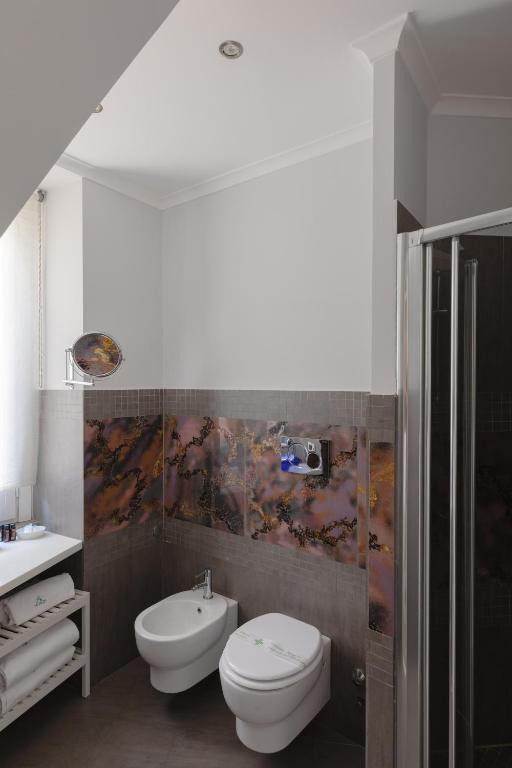 a bathroom with a toilet and a bidet and a sink at Relais Roma Centro in Rome