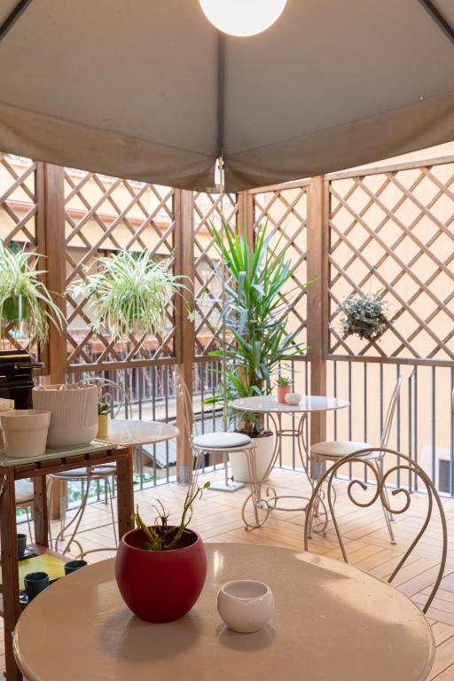 a room with tables and chairs and potted plants at Relais Roma Centro in Rome