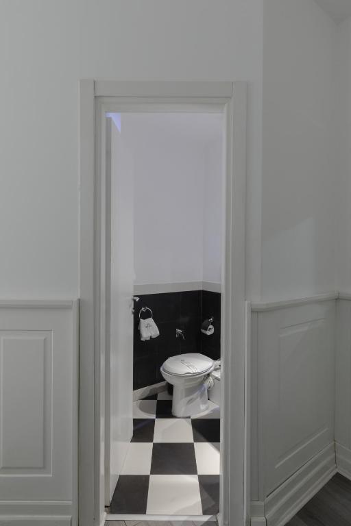 a bathroom with a toilet and a black and white checkered floor at Relais Roma Centro in Rome