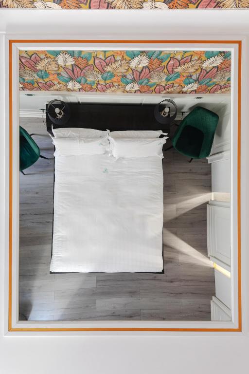 a picture of a bed with white sheets and pillows at Relais Roma Centro in Rome