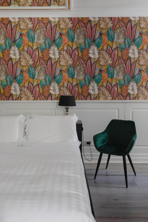 a bedroom with a bed and a green chair at Relais Roma Centro in Rome